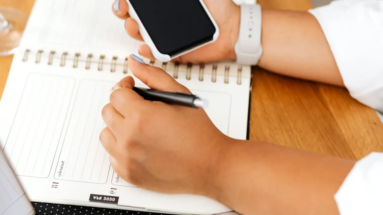 Aynı anda telefon, ajanda ve bilgisayarla çalışan kişi